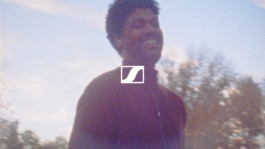 Portrait of a smiling person outdoors with soft focus, bathed in warm, natural light, giving the image a dreamy aesthetic. For Sennheiser, by Patrick Jaworek 